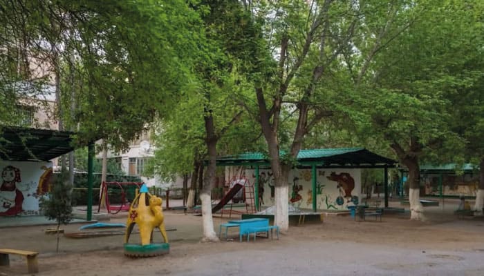 imagem de jardim de infância simples com alguns bancos e playgrounds