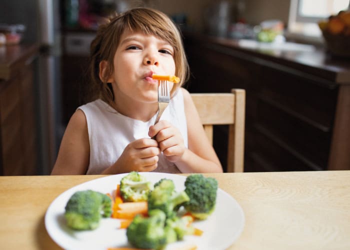 vista frontal bebe menina com legumes1 Meu filho tem 4 anos e não quer comer nada: como lidar com a seletividade alimentar infantil